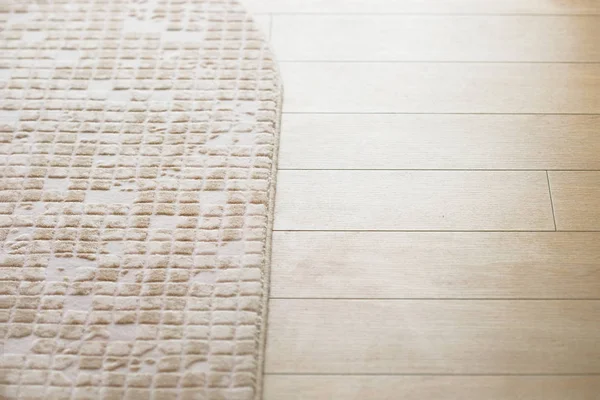 Suelo laminado parquete con alfombra suave beige — Foto de Stock