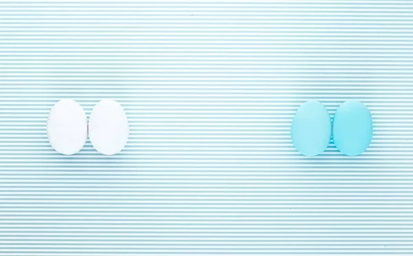 Ovos brancos e azuis sobre um fundo de listra horizontal — Fotografia de Stock