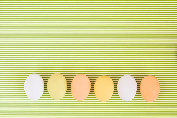 Visão superior cores pastel ovos linha no fundo verde — Fotografia de Stock