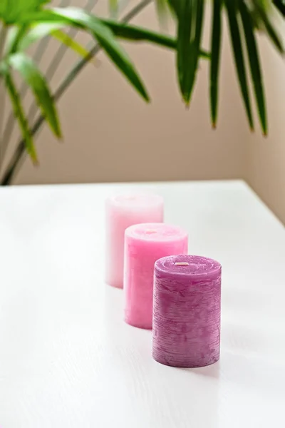 Tři růžové ombre vonné svíčky na bílém stole — Stock fotografie