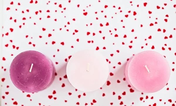 Serce trzy różowe świece na czerwonym tle — Zdjęcie stockowe