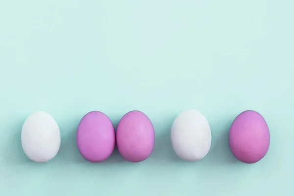 Row of colorful Easter eggs on blue background — Stock Photo, Image