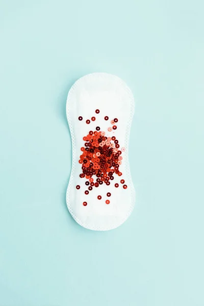 Pad menstruasi dengan glitter merah di latar belakang pastel — Stok Foto