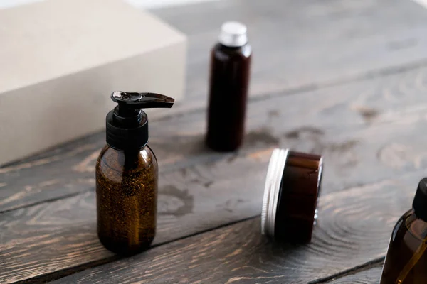 Donkerbruine glazen cosmetische flessen op houten — Stockfoto