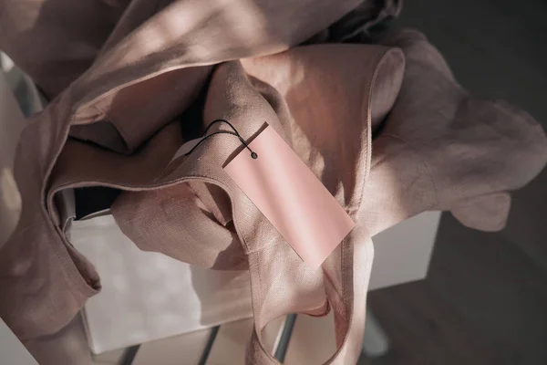 Розовое льняное платье с биркой в белой коробке — стоковое фото