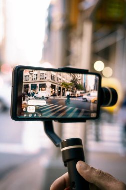 Ny 'da dengeleyicili telefonla canlı video çeken adam.