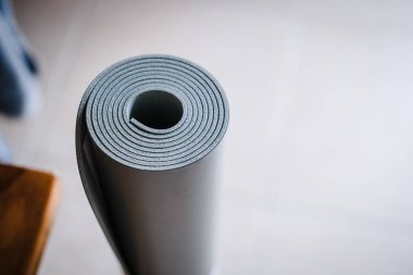 Pastel beyaz arka plan üzerinde yoga mat haddelenmiş