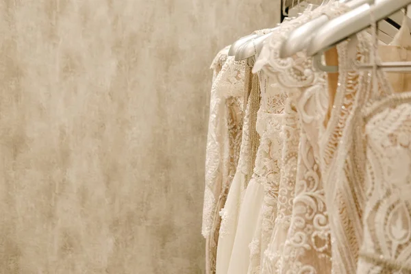 Cream wedding dresses hanging on the rack