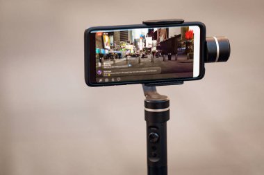 Dengeleyicili telefon, tripod, telsiz. New York 'ta fotoğraf çekip canlı video çekiyoruz. Vlog, video blogu, sokak fotoğrafçılığı konsepti. Kopyalama alanı