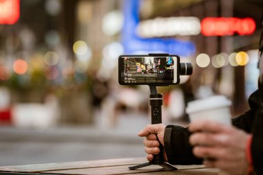 Dengeleyicili telefon, tripod, telsiz. New York 'ta fotoğraf çekip canlı video çekiyoruz. Vlog, video günlüğü, sokak fotoğrafçılığı kavramı. 