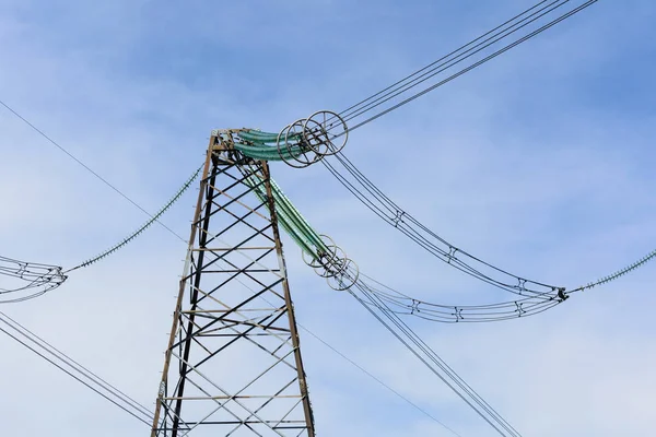 Hoogspannings-elektrische leidingen tegen de blauwe hemel. — Stockfoto