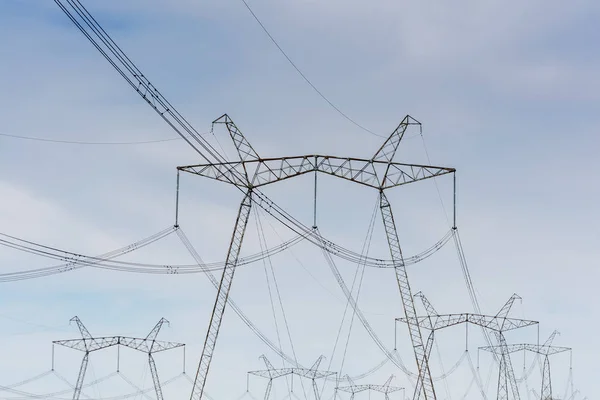 Líneas eléctricas de alto voltaje contra el cielo azul . — Foto de Stock