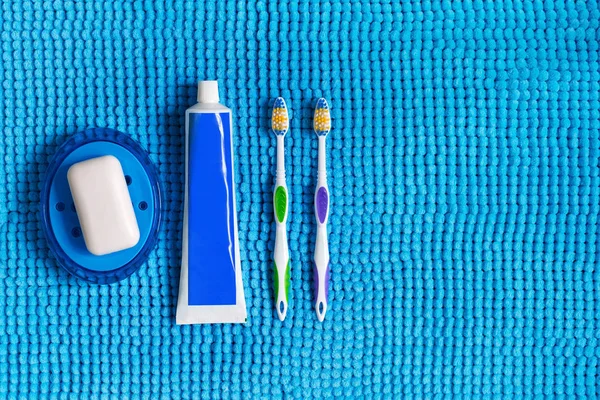 Blue soap dish with white soap, colored toothbrushes and tube of