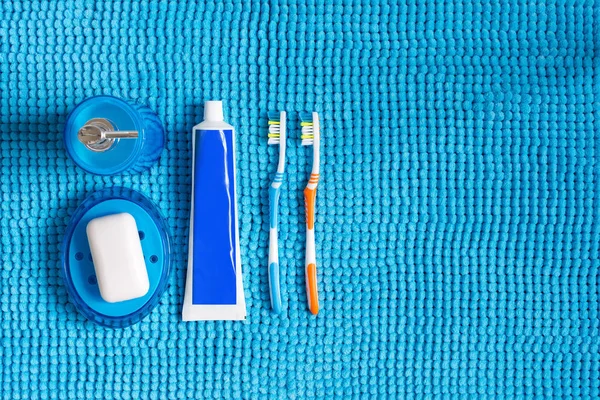 Colored toothbrushes, tube of toothpaste, blue dispenser for liq