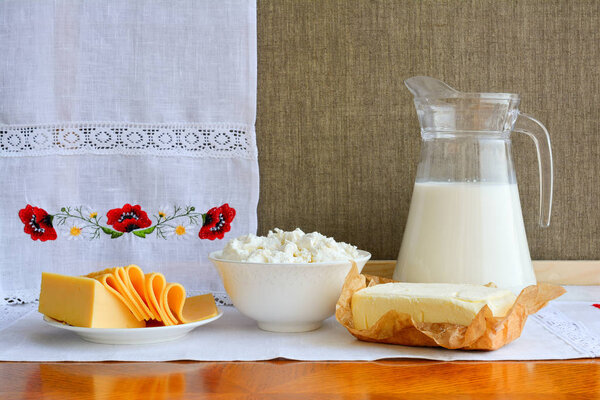 Still life of dairy products on background of towel with embroid