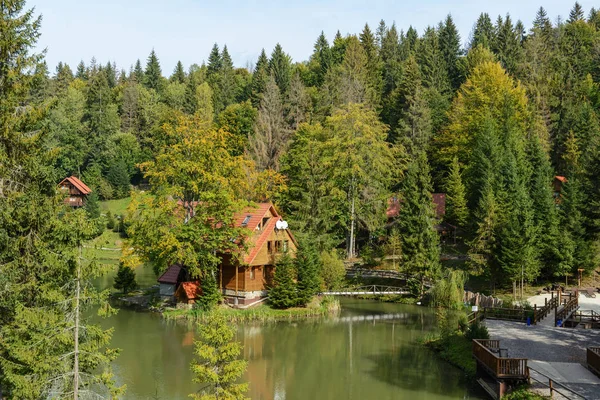 House near the lake in the forest, autumn day. — Stock Photo, Image