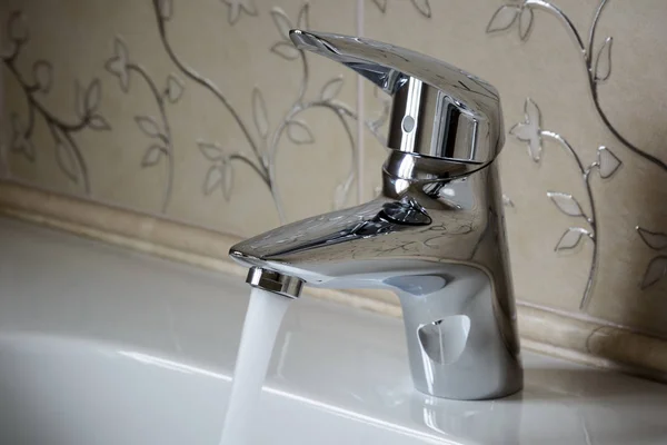 Single lever chromed mixer with running water in the bathroom, w — Stock Photo, Image