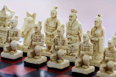 Çin tarzı bir satranç tahtası üzerinde oyulmuş satranç taşları.