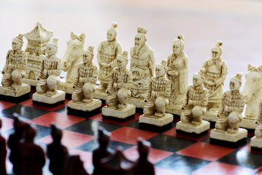 Çin tarzı bir satranç tahtası üzerinde oyulmuş satranç taşları.