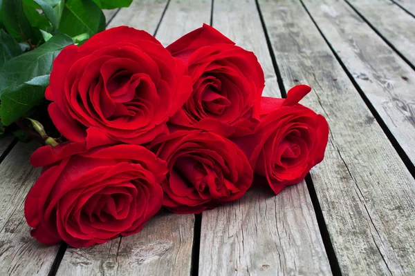 Bouquet rouge ou écarlate de roses avec des feuilles vertes sur fond de — Photo