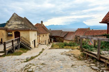 Antik kale kasabasının caddesi. Romanya 'nın tepedeki ortaçağ duvarlı Rasnov kenti. Ortaçağ Kalesi Rasnov ile sonbahar manzarası.
