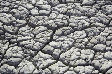 Derin çatlakları olan kuru toprak. Çamur yüzeyi çatlamış. Yerdeki çatlakların dokusu.