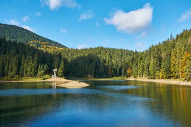 Sonbahar gününe kadar Synevir yüksek irtifa gölü manzarası. Yaprak düşer ormanlara, göle ve dağlara.