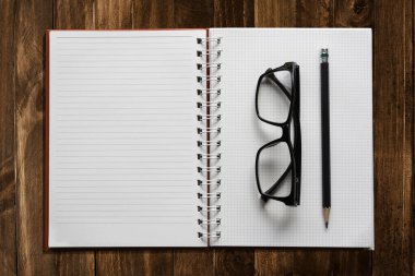 kitap açık kahverengi ahşap on line ile kalem ve gözlük