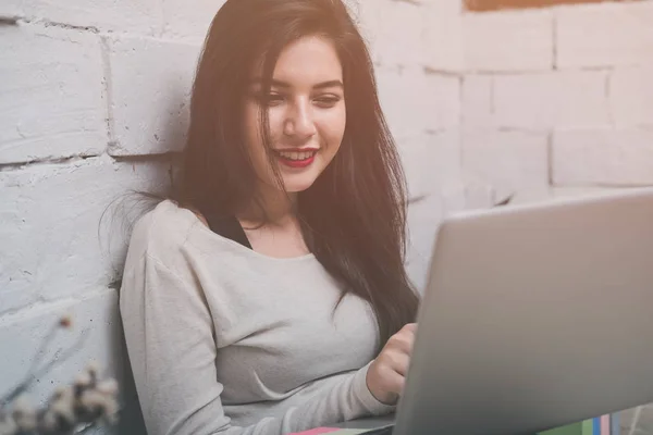 Jovem menina bonita trabalhando em um laptop em uma pequena empresa média — Fotografia de Stock