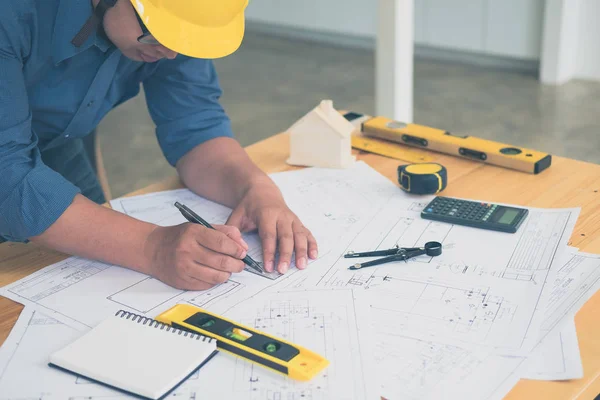 Architect or planner working on drawings for construction plans at a table