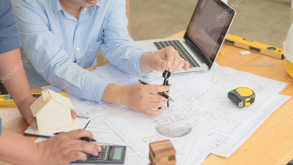 Architect or planner working on drawings for construction plans at a table