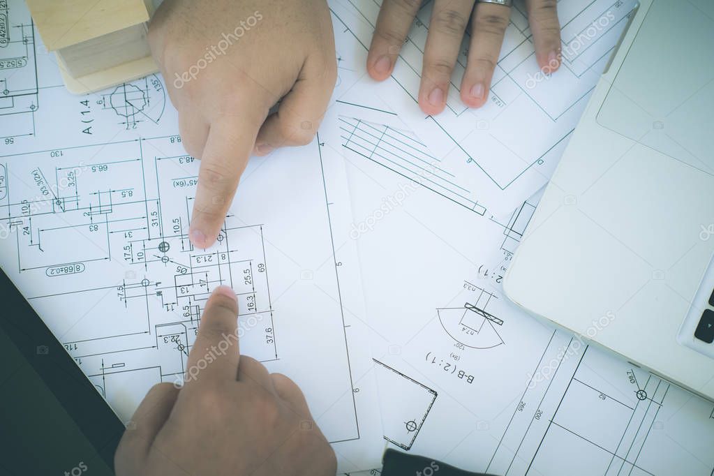 Architect or planner working on drawings for construction plans at a table
