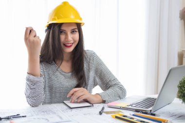 Bir masada inşaat planları için çizimler üzerinde çalışan mimar veya plancı