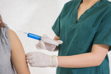 Yakın çekim ellerde, hemşireler şırıngayı kullanan hastalara aşılardır. Doktor, kadınları hastanede aşılıyor. Steril enjeksiyonla tedavi ediliyor. enjeksiyon,