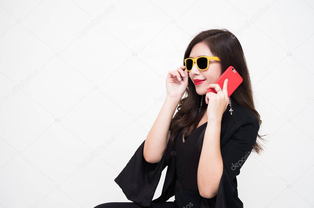 Young happy woman sitting at home while talking on phone with white background