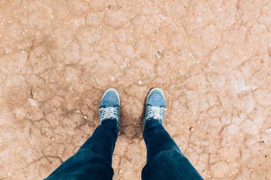 Ayaklara bakan, seçici odaklı bir adam.