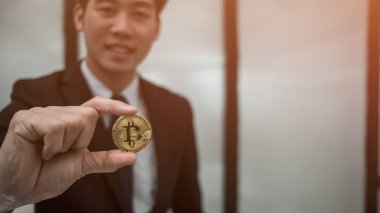 Bitcoin altın sikkesi elinde tutan işadamı, ticari tüccar konsepti