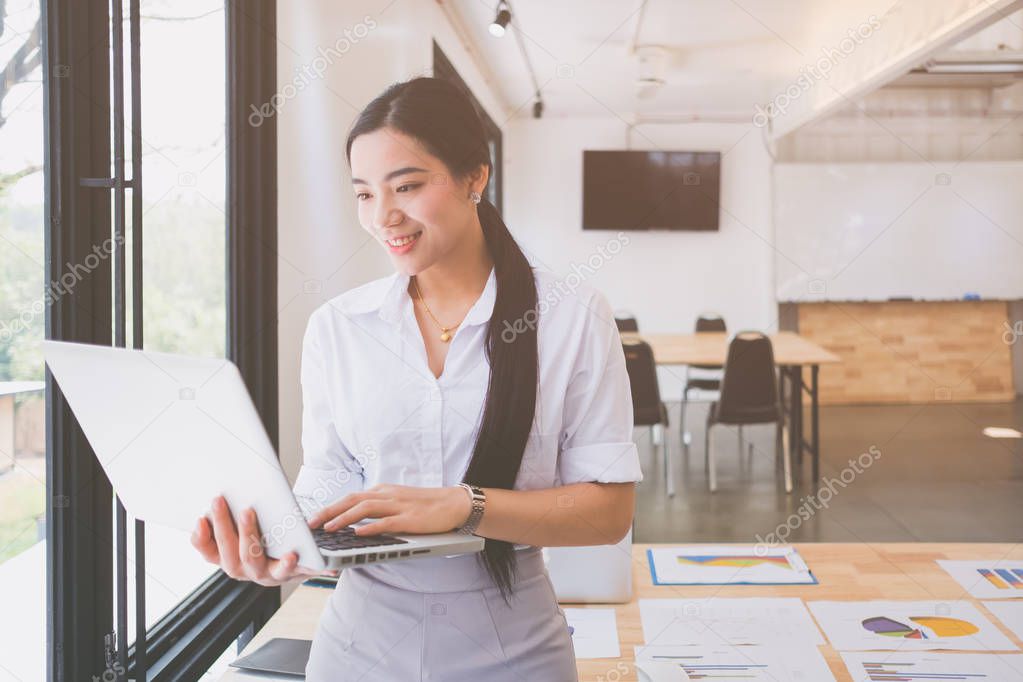 Portrait of smiling pretty young business woman on workplace, Calculating the cost of postage of a small package, Small business enterprise concerns for online Shopping 
