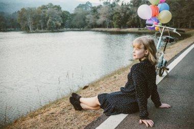 aşkın, yalnız kavramı gelmesini beklerken yolda tek başına oturan bir kadın