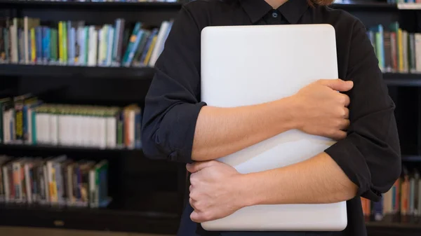 Kolları kavuşturulmuş, bilgisayarlara sarılan, işini seven biri.