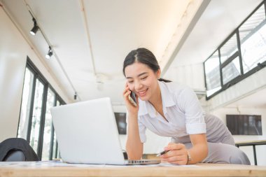 İş sektöründe masa başında çalışan genç Asyalı kadın.