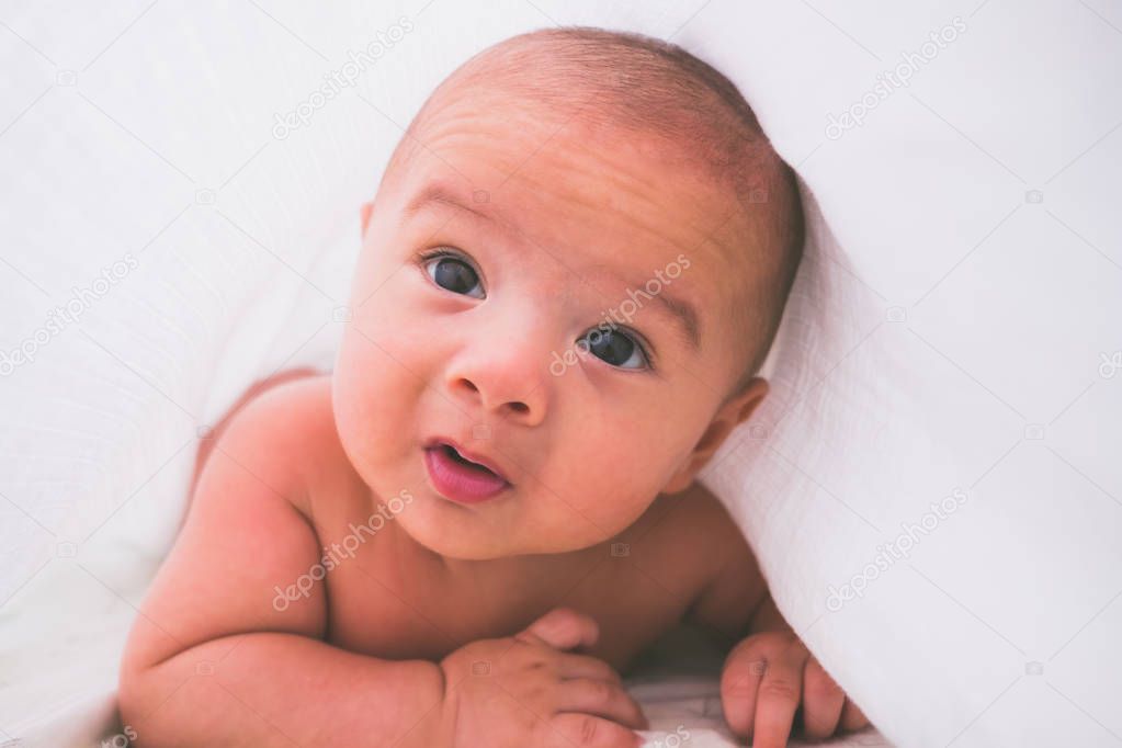 Portrait of a crawling baby on the bed in his room