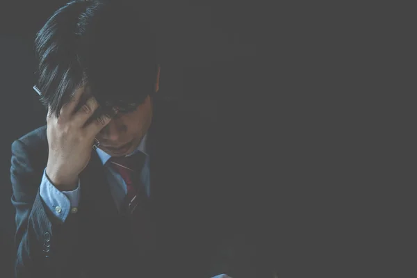 A stressed out business man holds his head in despair as he fears that he will have to file