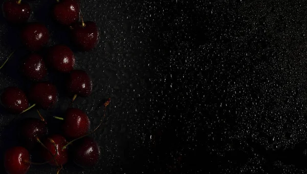 Cherry cherry berry on a black background there is a place for an inscription