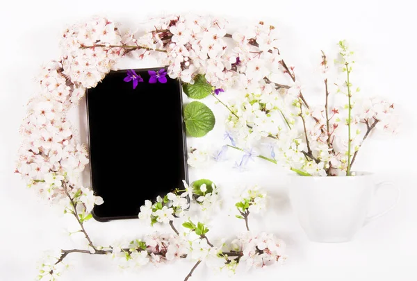 tablet and flowers spring fresh lie on a white table