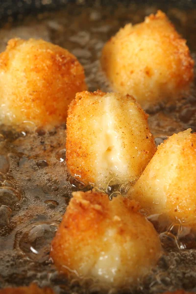 balls of cheese in breadcrumbs fried in oil