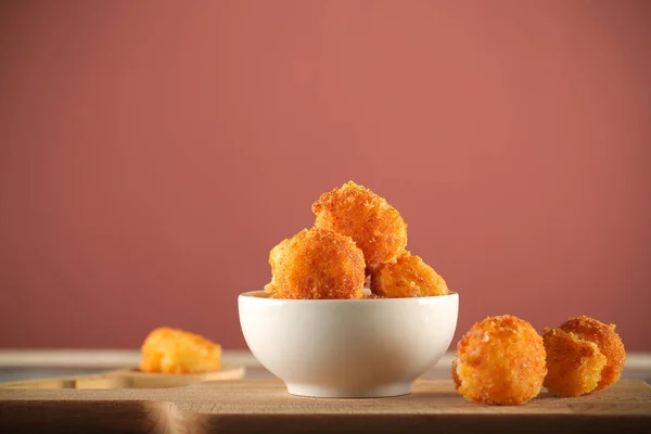 balls of cheese in breadcrumbs fried in oil