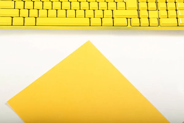 a yellow computer keyboard stands on a white background