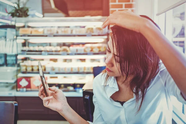 Las mujeres asiáticas están mirando su teléfono celular. centrarse en la cara . — Foto de Stock