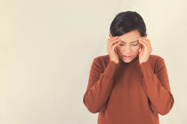 Asyalı kadın arka planda baş ağrısı çekiyor. Eline odaklan.